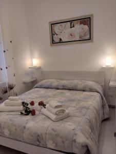 una camera da letto con un letto con asciugamani e fiori di Casa Vacanze Andrea la tua base per visitare il mare delle Cinque Terre a La Spezia