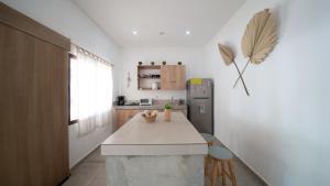 a kitchen with a counter and a refrigerator at Coco Surf Tropical Village in La Libertad