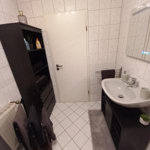 een witte badkamer met een wastafel en een douche bij Ferienwohnung Weinand in Birresborn