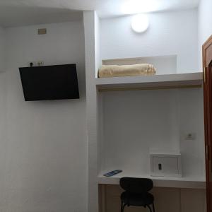 Una habitación con un televisor en una pared con una silla. en Hotel Casa del Sol, en Puerto de la Cruz