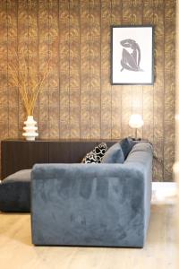 un soggiorno con divano blu di fronte a un muro di Mr.Bernard Vakantie Appartementen a De Panne