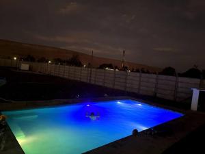 a large blue swimming pool at night at Casa en Valle de Azapa km2 in Arica