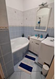 a bathroom with a tub and a sink and a mirror at Esztergom apartman in Esztergom