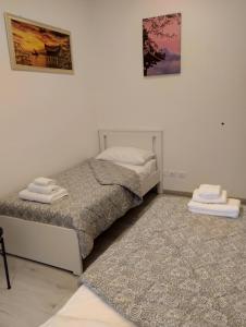 2 letti in una camera bianca con 2 tappeti di Casa Vacanze Andrea la tua base per visitare il mare delle Cinque Terre a La Spezia