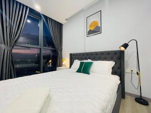 een slaapkamer met een groot bed en een raam bij Sunrise & Sunset Apartment View Marina Suites in Nha Trang