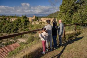 un grupo de personas de pie en una colina mirando a una ciudad en Can Feló, en Tavertet