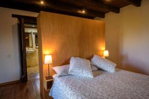 1 dormitorio con 1 cama con 2 almohadas y 2 lámparas en Can Feló, en Tavertet