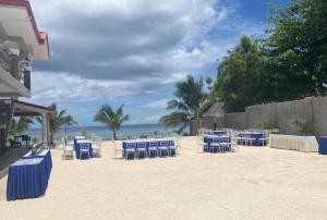 a group of blue chairs and tables on the beach at Lawson’s Beach Resort in San Juan