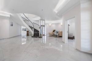 a white hallway with a spiral staircase in a house at Luxury Emirates Private Villa in Dubai Jumeirah in Dubai