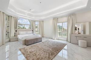a white bedroom with a bed and a large window at Luxury Emirates Private Villa in Dubai Jumeirah in Dubai