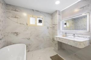 a white bathroom with a sink and a mirror at Luxury Emirates Private Villa in Dubai Jumeirah in Dubai