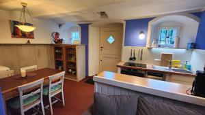 een keuken met blauwe muren en een tafel en een wastafel bij Idyllische Alte Schmiede beim Sorpesee in Melschede