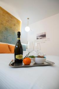 a bottle of wine and a bowl of fruit on a tray at Guest House Azzurra in Lampedusa