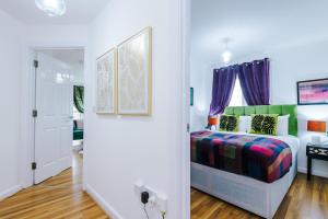 a bedroom with a bed with purple curtains at Charming 2Bed Retreat in Historic Coventry in Coventry