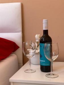 een fles wijn en twee wijnglazen op een tafel bij Esztergom apartman in Esztergom