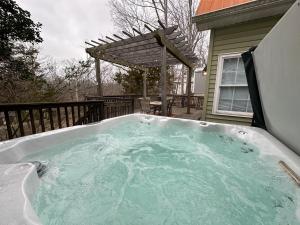 un bain à remous dans un jardin avec une pergola dans l'établissement Driftwood Cottage with Hot Tub on Lake Cumberland, à Russell Springs