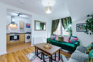 a living room with a green couch and a table at Charming 2Bed Retreat in Historic Coventry in Coventry