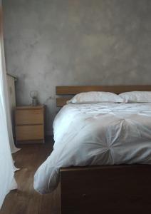 a bedroom with a white bed and a night stand at Appartamento - Rho Centro 6 - in Rho