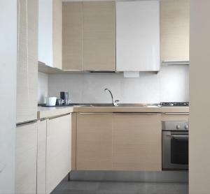una cocina con armarios blancos y fregadero en Appartamento - Rho Centro 6 -, en Rho