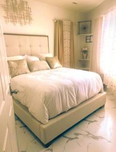 a bedroom with a large bed with white sheets at Beautiful Queen Luxury Suite Near Downtown Norfolk in Norfolk