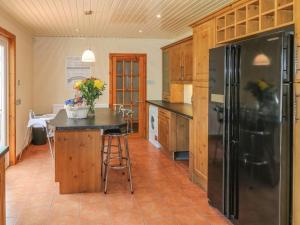 a kitchen with a black refrigerator and a table at Luxurious 5 bedroom house with games room in Kingholm Quay
