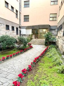 a row of red flowers in front of a building at Matilda Guest House EUR 4 posti letto in Rome