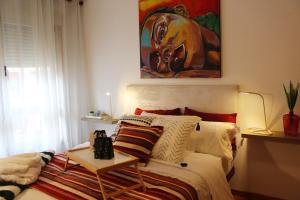 a bedroom with a bed with a painting on the wall at Apartamento Centro de Pontevedra in Pontevedra
