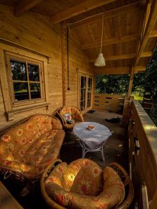 een veranda van een hut met stoelen en een tafel bij Hulajdusza in Gościno