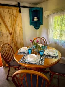 une table en bois avec des chaises, des assiettes et des fleurs. dans l'établissement Hulajdusza, à Gościno