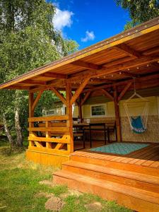 een houten paviljoen met een tafel en een hangmat bij Hulajdusza in Gościno