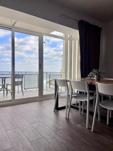 comedor con mesa y sillas y balcón en Sea-mist luxury escape en St Julian's