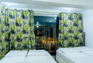 a room with two beds and a window with curtains at RedDoorz @ Yahweh Spring Retreat & Resort Laguna in Calamba