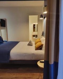 a bedroom with a large bed with pillows on it at Hotelo Lyon Ainay in Lyon