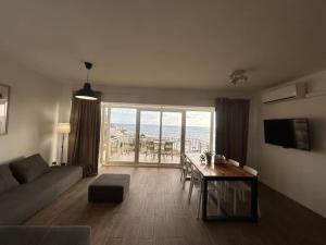 a living room with a couch and a table with a view at Sea-mist luxury escape in St. Julianʼs