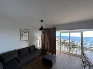 sala de estar con sofá y vistas al océano en Sea-mist luxury escape, en San Julián