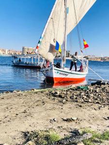 a man on a sail boat on the beach at Felucca Sailing Boat Overnight Experience in Aswan