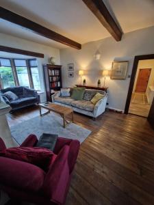 ein Wohnzimmer mit einem Sofa und einem Tisch in der Unterkunft Briar Cottage Guest Suite in Norwood Green, Halifax in Halifax
