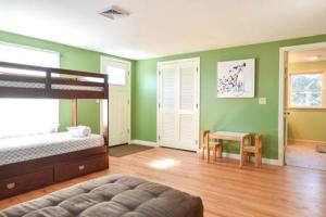 ein Schlafzimmer mit grünen Wänden, einem Bett und einem Tisch in der Unterkunft Mins to Nauset Beach & Walkable to Town in Orleans