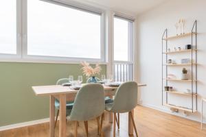 une salle à manger avec une table en bois et des chaises vertes dans l'établissement Lille St.Maur - Nice and functional ap., à Lille 12 autres photos
