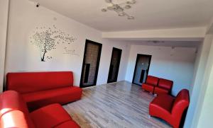 ein Wohnzimmer mit roten Stühlen und einem roten Sofa in der Unterkunft Ridos in Constanţa