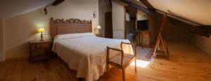 1 dormitorio con 1 cama grande y suelo de madera en Paraiso del Bierzo, en Las Herrerías