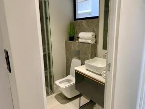a bathroom with a toilet and a sink at OAM The Paramount Rosebank Luxury One-Bedroom in Johannesburg