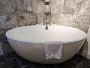 La salle de bains est pourvue d'une baignoire blanche et d'une serviette. dans l'établissement Lake View Country House, à Grasmere