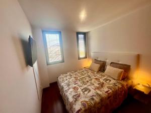 a bedroom with a bed and two windows at 29 Floor. Home Suite Home in Santa Cruz de Tenerife