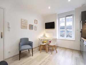 a living room with a table and chairs and a window at Residence Louis Quartier Gare in Vittel