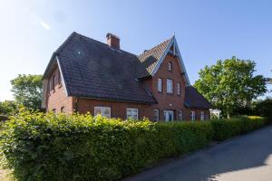 a large red brick house with a black roof at Hardesweg 63 Nummer 1 in Wrixum