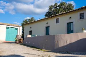 una casa blanca con una puerta azul y una valla en La Dimora delle Coste en Comiso