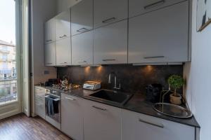a kitchen with white cabinets and a sink at [Centro] Splendido Appartamento di Design in Turin