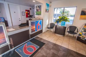 a fast food restaurant with a cash register and chairs at Motel 6-Ft. Pierce, FL in Fort Pierce