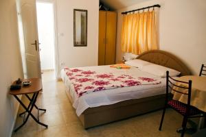 1 dormitorio con cama, mesa y ventana en Apartments Radonjic, en Budva